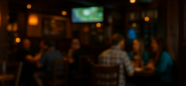 Cozy pub interior with tables and TVs showing the game
